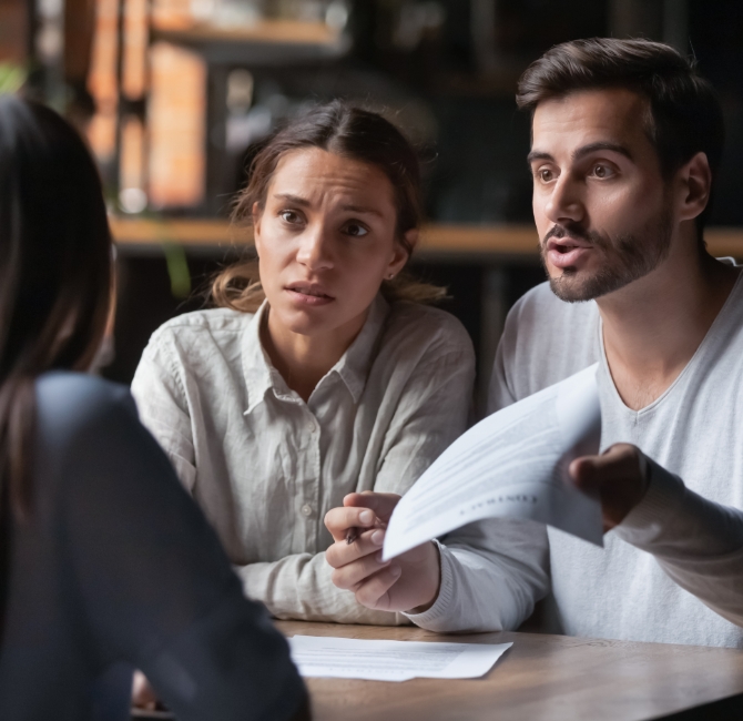 Couple upset reviewing paperwork with lawyer