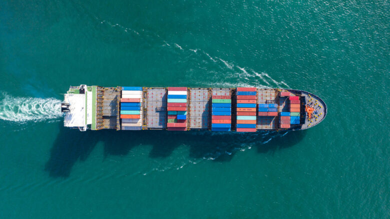 In an aerial view, the crewmates of an injured worker gather on the forward deck of a container ship. The injured worker could get compensation from a Jones Act Claim.